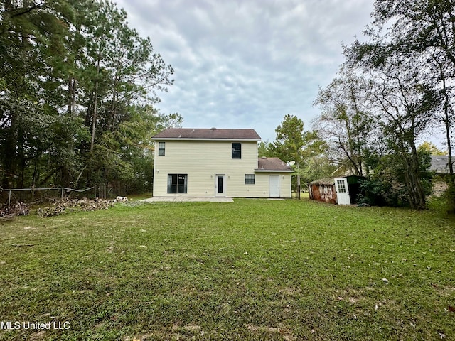 rear view of house with a patio and a lawn