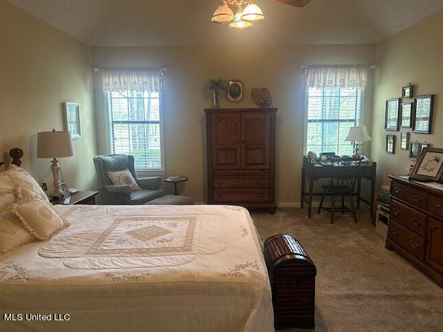 bedroom with light carpet, multiple windows, and lofted ceiling