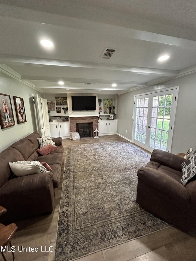 507 Reed Dr, Cleveland, MS 38732 - living room with beamed ceiling, a brick fireplace, french doors, recessed lighting, and wood finished floors