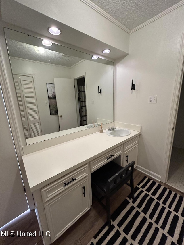 507 Reed Dr, Cleveland, MS 38732 - bathroom featuring wood finished floors, vanity, ornamental molding, a textured ceiling, and baseboards