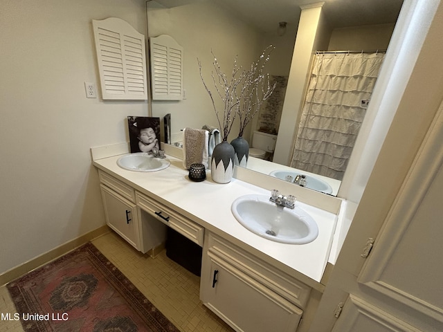507 Reed Dr, Cleveland, MS 38732 - full bathroom featuring toilet, double vanity, baseboards, curtained shower, and tile patterned flooring