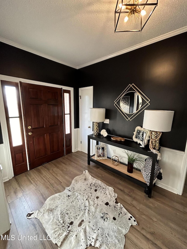 507 Reed Dr, Cleveland, MS 38732 - foyer with wood finished floors, crown molding, a chandelier, a textured ceiling, and wainscoting