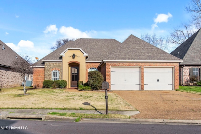 view of front facade with brick siding, an attached garage, a shingled roof, a front yard, and driveway