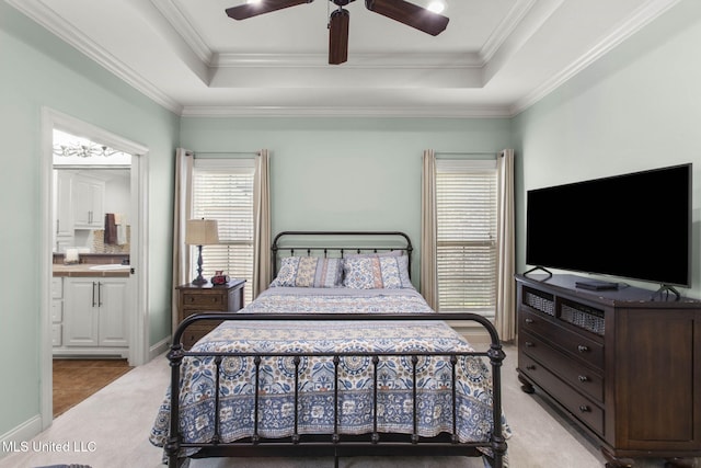 bedroom with ensuite bathroom, carpet, a tray ceiling, and ornamental molding