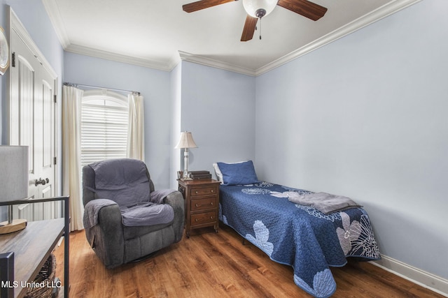 bedroom with ceiling fan, crown molding, baseboards, and wood finished floors