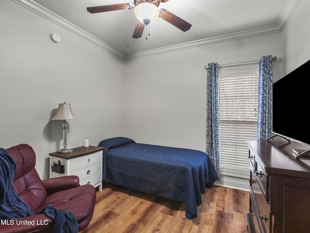 bedroom featuring crown molding, a ceiling fan, and wood finished floors