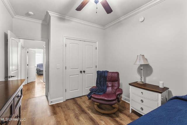 bedroom featuring crown molding, wood finished floors, a closet, and baseboards