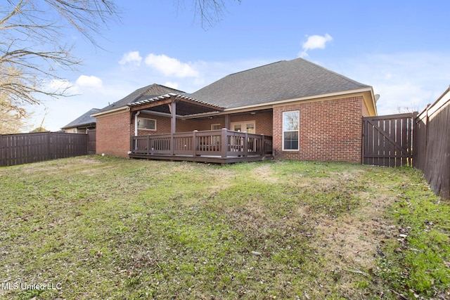 rear view of house with a pergola, a fenced backyard, brick siding, and a wooden deck