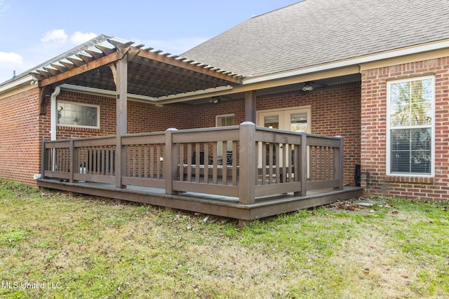 back of house featuring a yard, brick siding, and roof with shingles