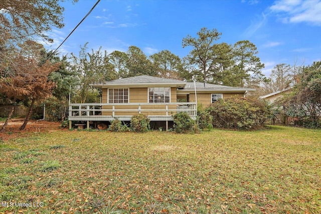 back of property with a wooden deck and a yard