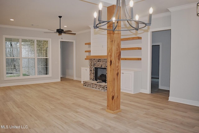 unfurnished living room with crown molding, a fireplace, light hardwood / wood-style floors, and ceiling fan with notable chandelier