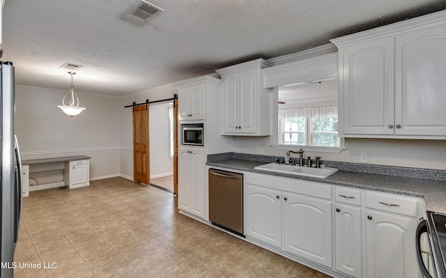 315 Church St, Madison, MS 39110 - kitchen featuring stainless steel appliances, a sink, a barn door, a textured ceiling, and white cabinets