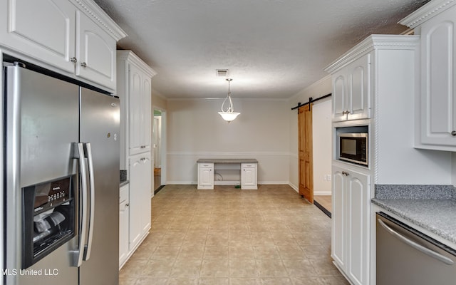 315 Church St, Madison, MS 39110 - kitchen featuring appliances with stainless steel finishes, white cabinets, a barn door, a textured ceiling, and pendant lighting