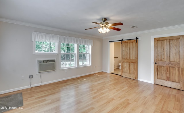 315 Church St, Madison, MS 39110 - unfurnished bedroom featuring a barn door, light wood-style flooring, ornamental molding, baseboards, and an AC wall unit