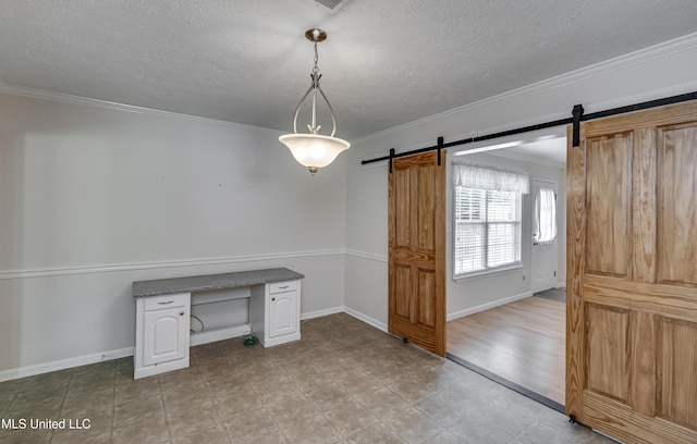 315 Church St, Madison, MS 39110 - unfurnished dining area with a barn door, a textured ceiling, ornamental molding, and baseboards