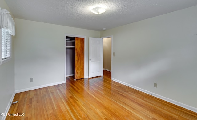 315 Church St, Madison, MS 39110 - unfurnished bedroom with baseboards, a textured ceiling, light wood-type flooring, and a closet