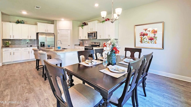 15109 Windmill Ridge Parkway, Diberville, MS 39540 - dining space with light wood-type flooring, a chandelier, and recessed lighting