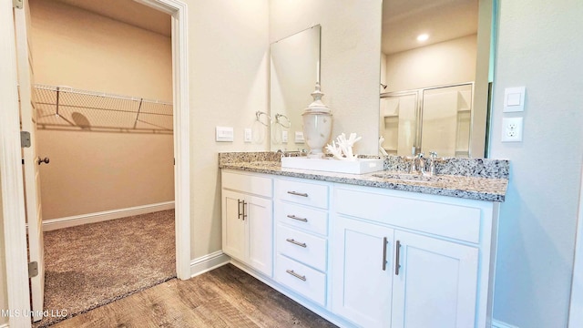15109 Windmill Ridge Parkway, Diberville, MS 39540 - bathroom featuring double vanity, wood finished floors, a shower stall, and a spacious closet