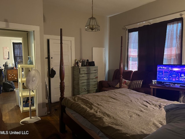 bedroom with an inviting chandelier and hardwood / wood-style floors