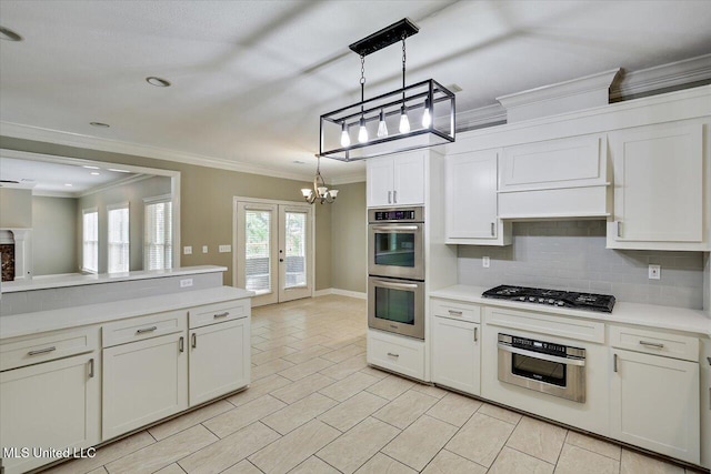 207 Keystone Pl, Brandon, MS 39042 - kitchen featuring appliances with stainless steel finishes, crown molding, a chandelier, backsplash, and light countertops