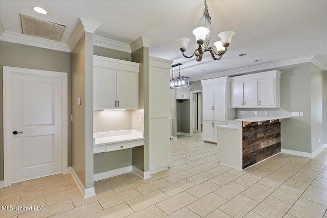 207 Keystone Pl, Brandon, MS 39042 - kitchen featuring a chandelier, crown molding, a peninsula, white cabinetry, and decorative light fixtures