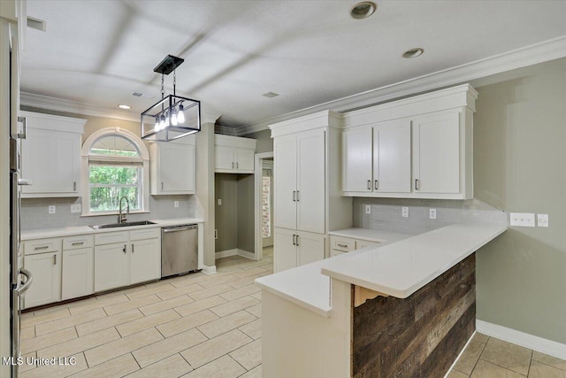 207 Keystone Pl, Brandon, MS 39042 - kitchen with stainless steel dishwasher, a sink, crown molding, a peninsula, and decorative backsplash