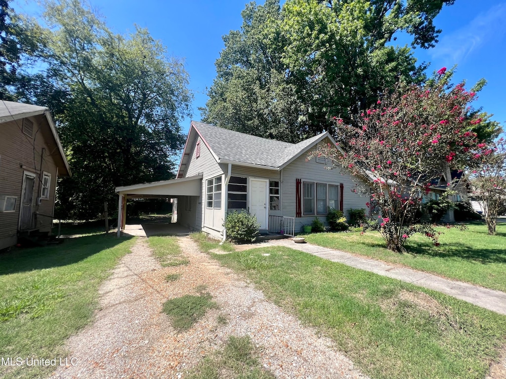 view of front of house with a front lawn and a carport