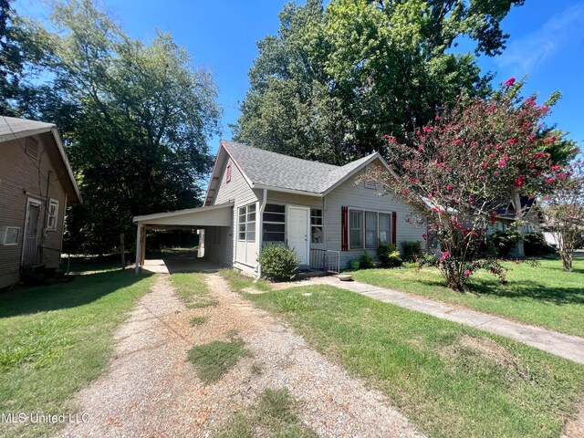 view of front of house with a front lawn and a carport