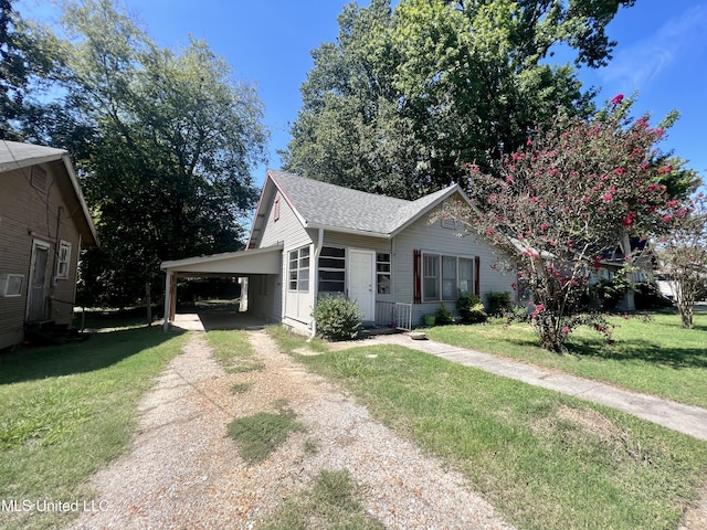 205 N Victoria Ave, Cleveland, MS 38732 - view of front of house featuring a front lawn, a shingled roof, driveway, and an attached carport