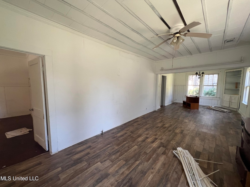 unfurnished living room with dark wood-type flooring, built in features, and ceiling fan