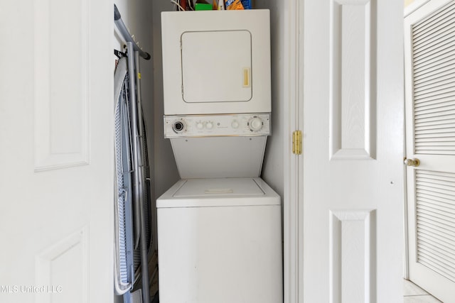 washroom featuring stacked washer / dryer and laundry area