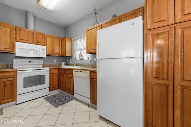 kitchen featuring white appliances, light countertops, a sink, and light tile patterned flooring