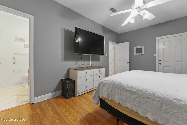 bedroom with light wood finished floors, visible vents, a ceiling fan, connected bathroom, and baseboards