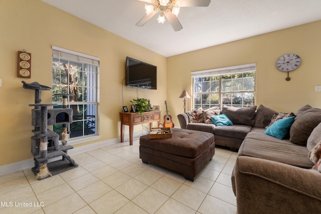 living room with ceiling fan, baseboards, a wealth of natural light, and light tile patterned flooring