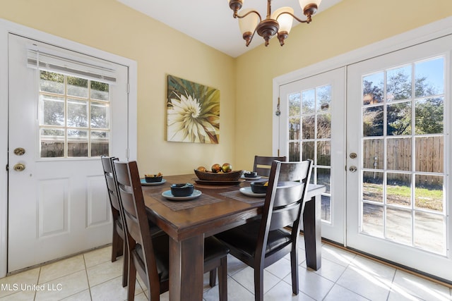 dining room featuring a wealth of natural light, french doors, a notable chandelier, and light tile patterned floors