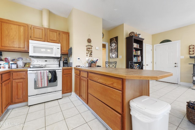 kitchen with light tile patterned floors, a peninsula, white appliances, and tile countertops