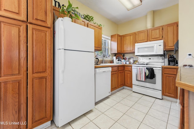 kitchen featuring white appliances, light countertops, a sink, and light tile patterned floors