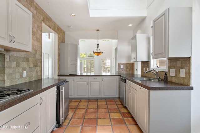 kitchen with appliances with stainless steel finishes, a healthy amount of sunlight, sink, and pendant lighting