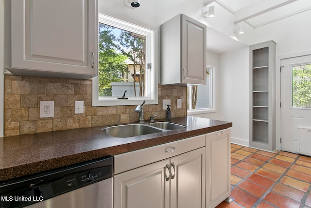 kitchen featuring light tile patterned flooring, decorative backsplash, sink, and stainless steel dishwasher