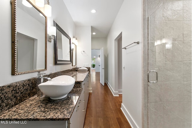 bathroom with a shower with door, vanity, and wood-type flooring