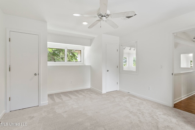 carpeted empty room featuring a healthy amount of sunlight and ceiling fan