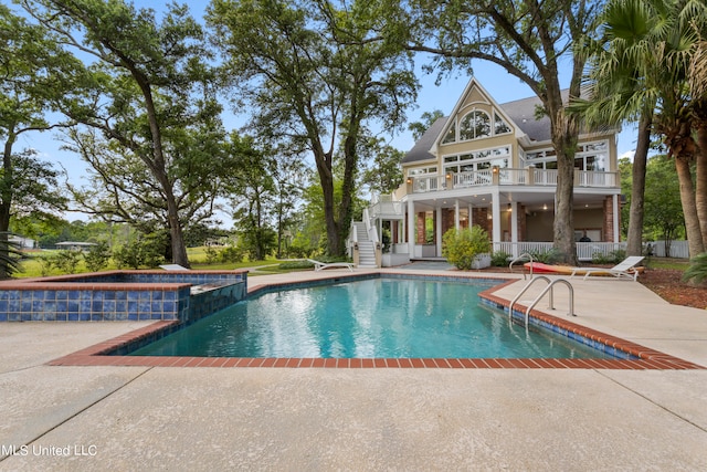 view of swimming pool featuring an in ground hot tub and a patio area