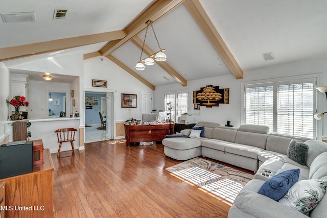 living room featuring lofted ceiling with beams and light hardwood / wood-style flooring