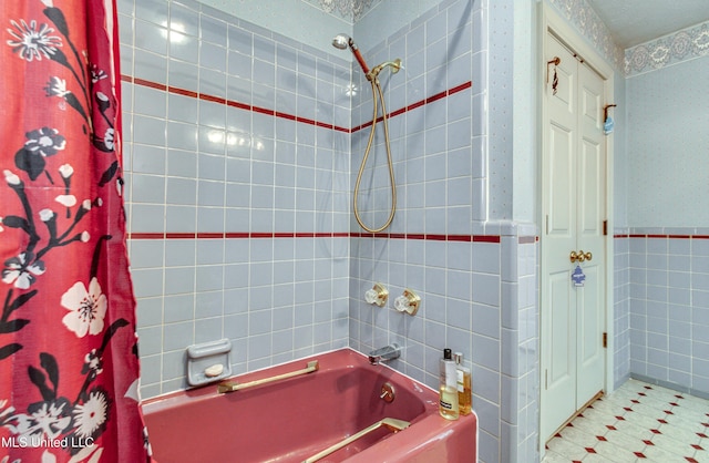 bathroom featuring shower / bath combination with curtain, a textured ceiling, and tile walls