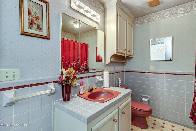 bathroom featuring vanity, a textured ceiling, toilet, and tile walls