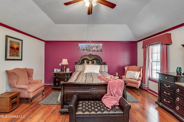 bedroom with hardwood / wood-style floors, crown molding, vaulted ceiling, ceiling fan, and a textured ceiling