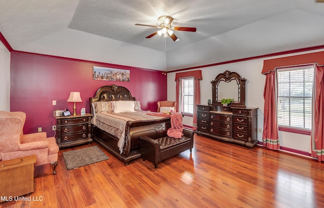 bedroom with hardwood / wood-style flooring, ceiling fan, crown molding, and vaulted ceiling