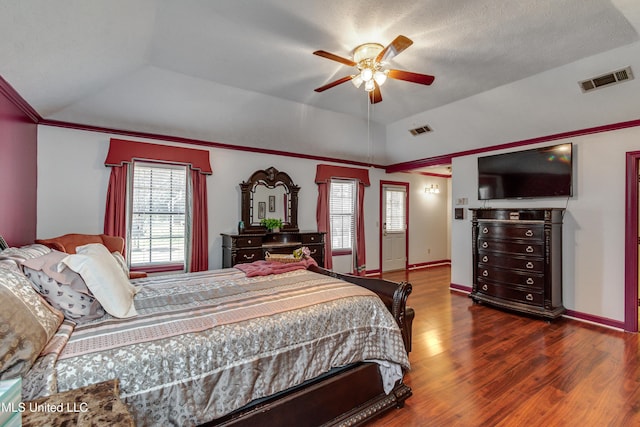 bedroom featuring ceiling fan, dark hardwood / wood-style flooring, crown molding, vaulted ceiling, and a textured ceiling