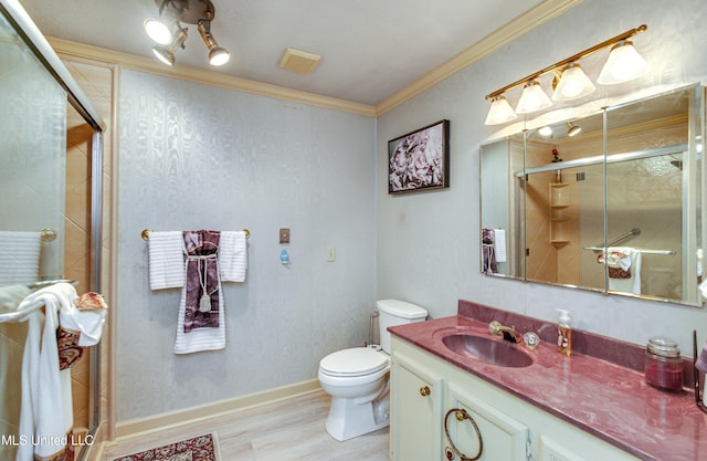 bathroom featuring hardwood / wood-style floors, toilet, a shower with door, vanity, and ornamental molding