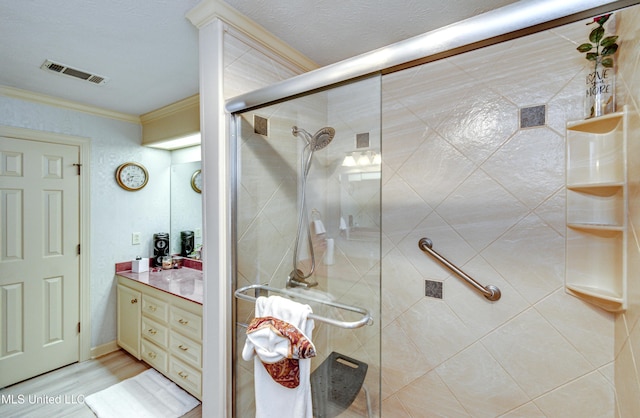 bathroom with vanity, hardwood / wood-style flooring, a shower with shower door, and crown molding